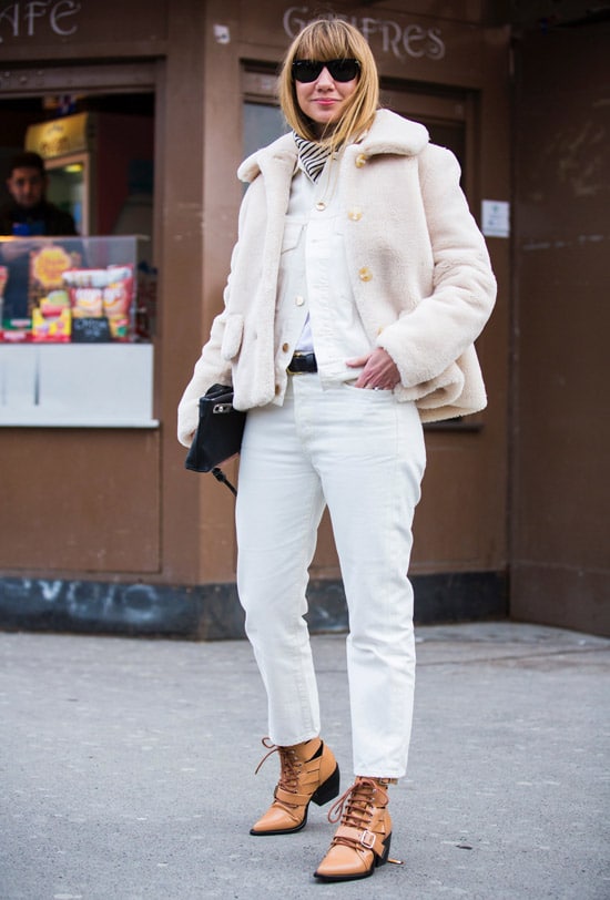 Девушка в белых джинсах, меховая куртка и бежевые ботинки