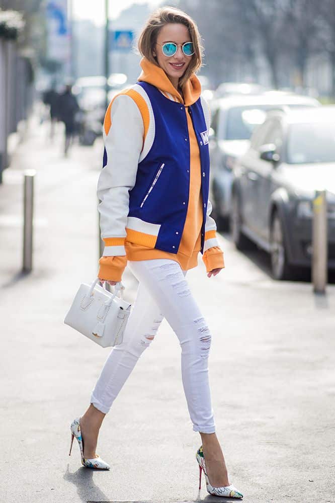 Девушка в белых рваных джисаз и куртка в спортивном стиле
