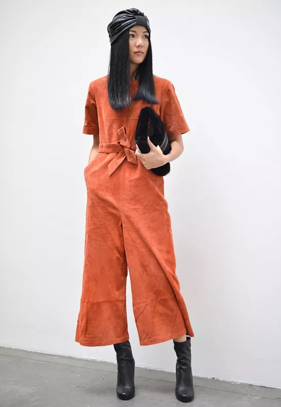 Девушка в оранжевом комбинезоне, черные ботильоны и платок на голове