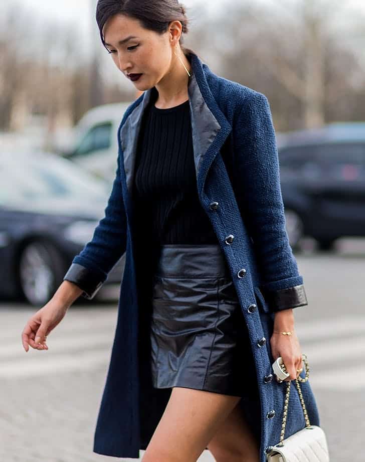 Девушка в черной мини юбке и синем пальто
