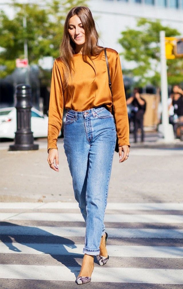 Девушка в джинсах и оранжевой блузке