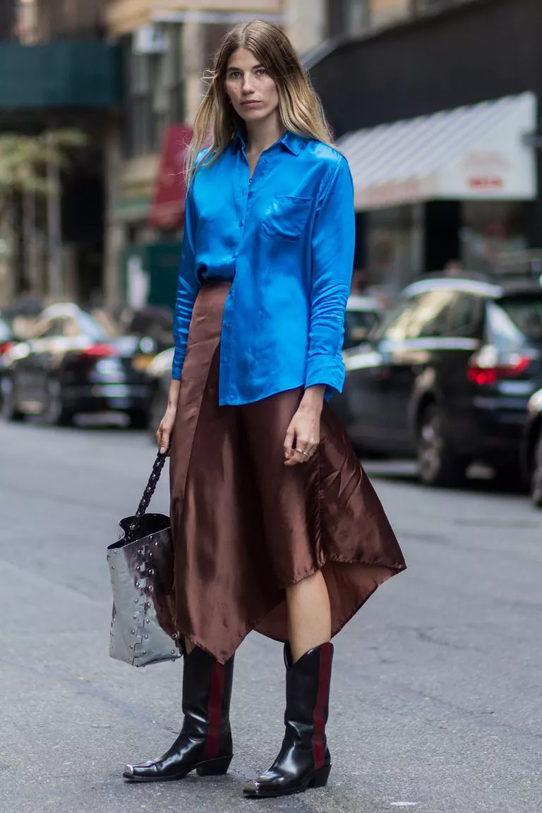 Девушка в коричневой юбке миди, синяя блузка и ковбойские сапоги