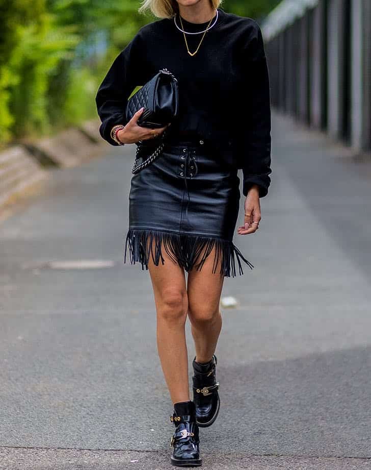 Девушка в мини юбке с бахромой, черный свитер и ботинки