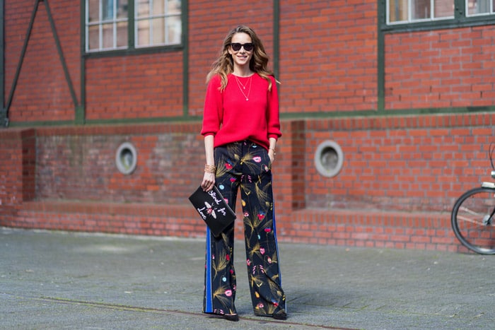 Девушка в широких брюках с цветами и красном свитере