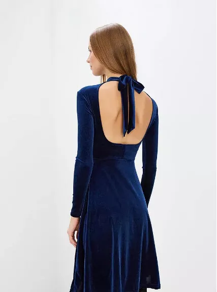Модель в синем бархатном платье с открытой спиной