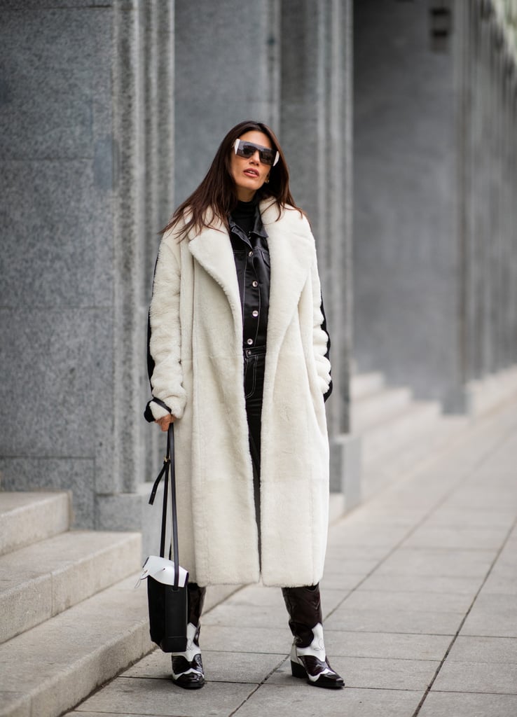 Девушка в белом длинном пальто и черные сапоги