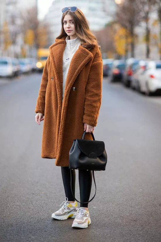 Девушка в корочневом плюшевом пальто, леггинсы и кроссовки