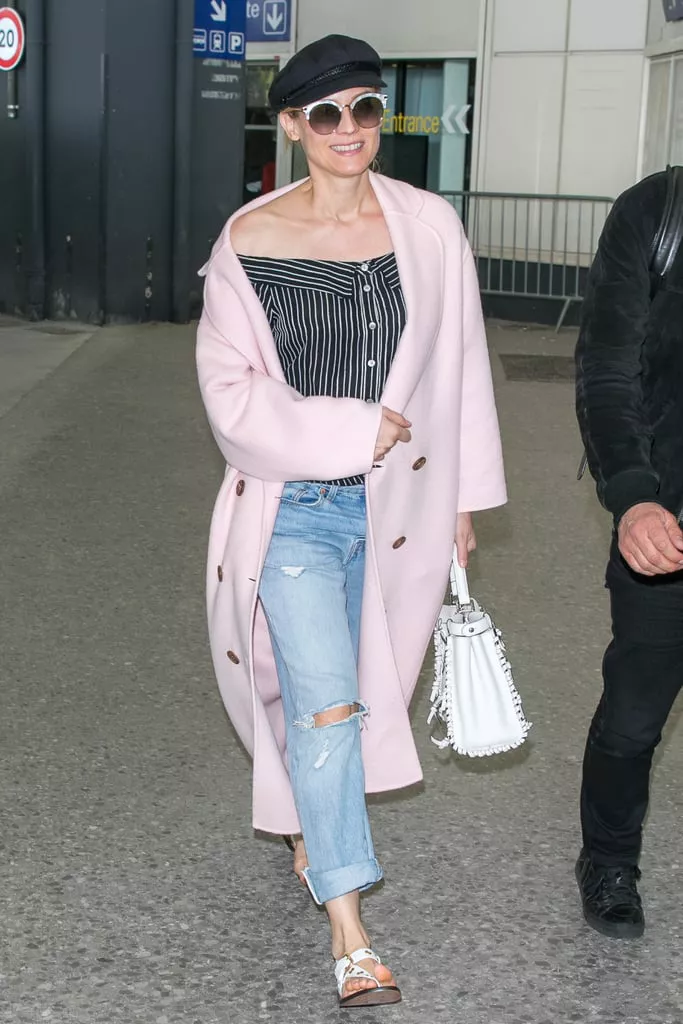 Diane Kruger в голубых джинсах, черный топ и розовое пальто