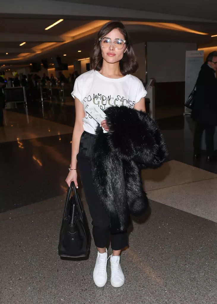 Olivia Culpo в черных рюках, бела футболка и большая сумка