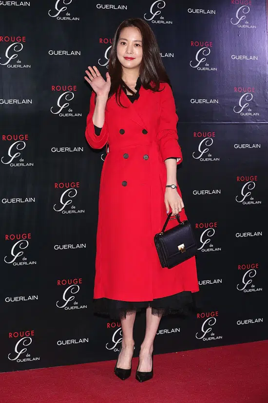 Девушка в красном пальто миди и черных туфлях