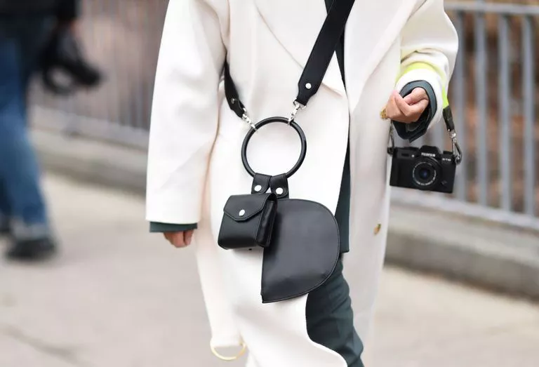 Девушка в белом пальто и черной сумке