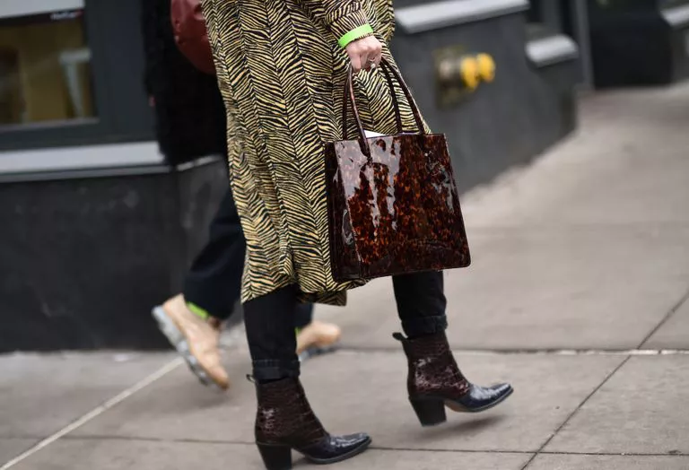Девушка в пальто, коричневые ботильоны и лакированная сумка