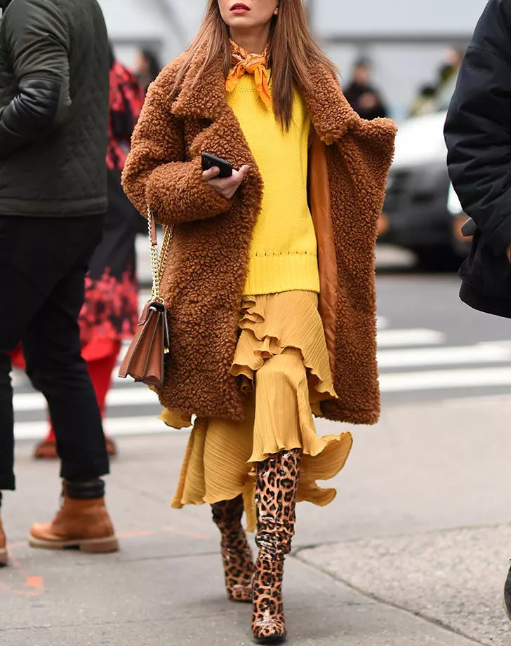 Девушка в желтом свитере, легкая юбка, плюшевое пальто и леопардовые сапоги