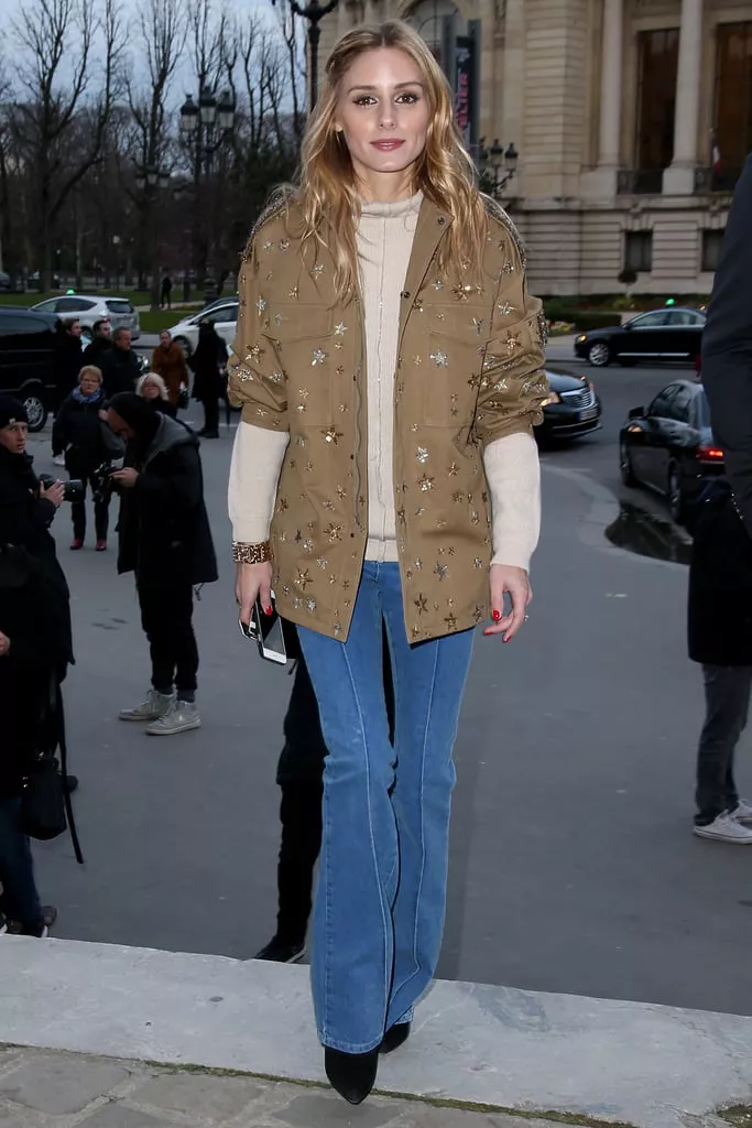 Оливия Палермо в синих джинсах клеш и коричневой куртке