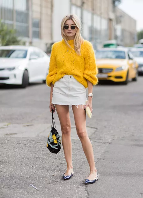 Девушка в бело мини юбке и желтом свитере