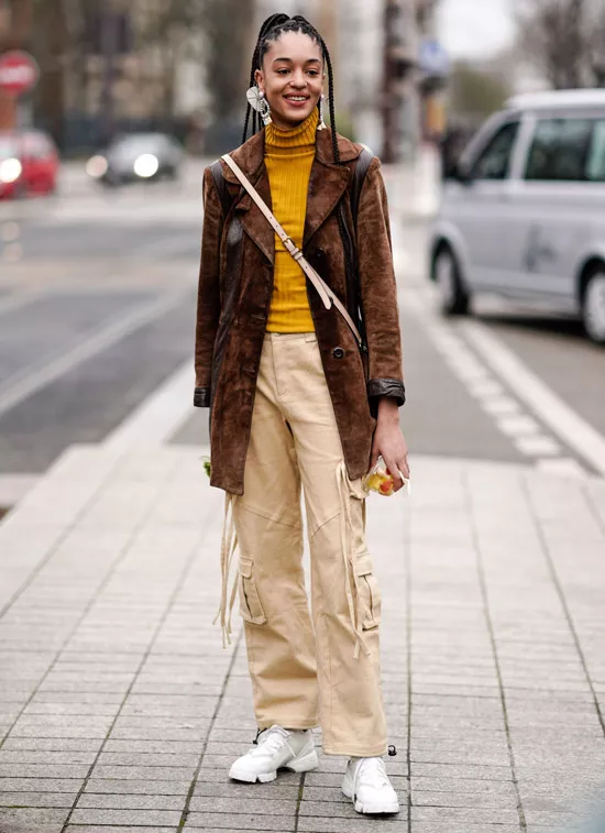 Девушка в бежевых брюках, желтая водолазка и коричневый жакет