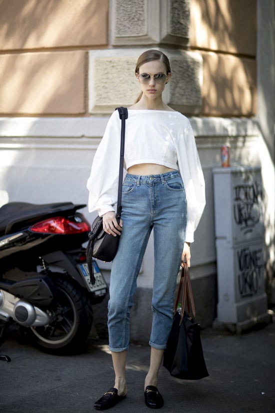 Девушка в джинсах с высоко талией и укроченной белой блузке