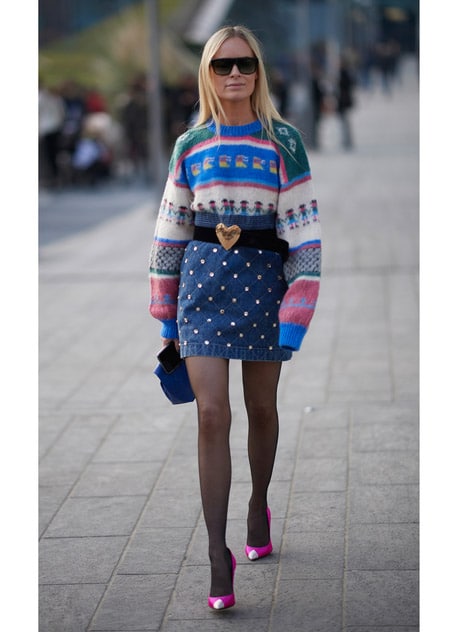 Девушка в мини юбке со стразами и разноцветном свитере