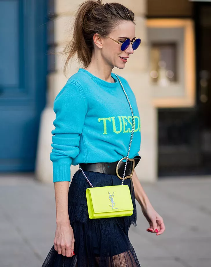 Девушка в синем джемпере, синей юбке и желтая сумка