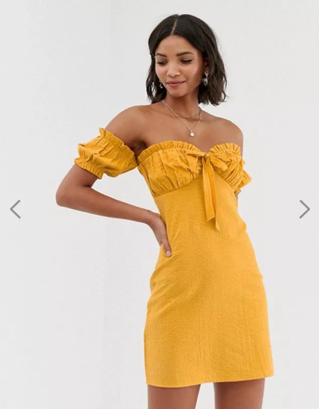Модель в желтом платье мини с открытыми плечами