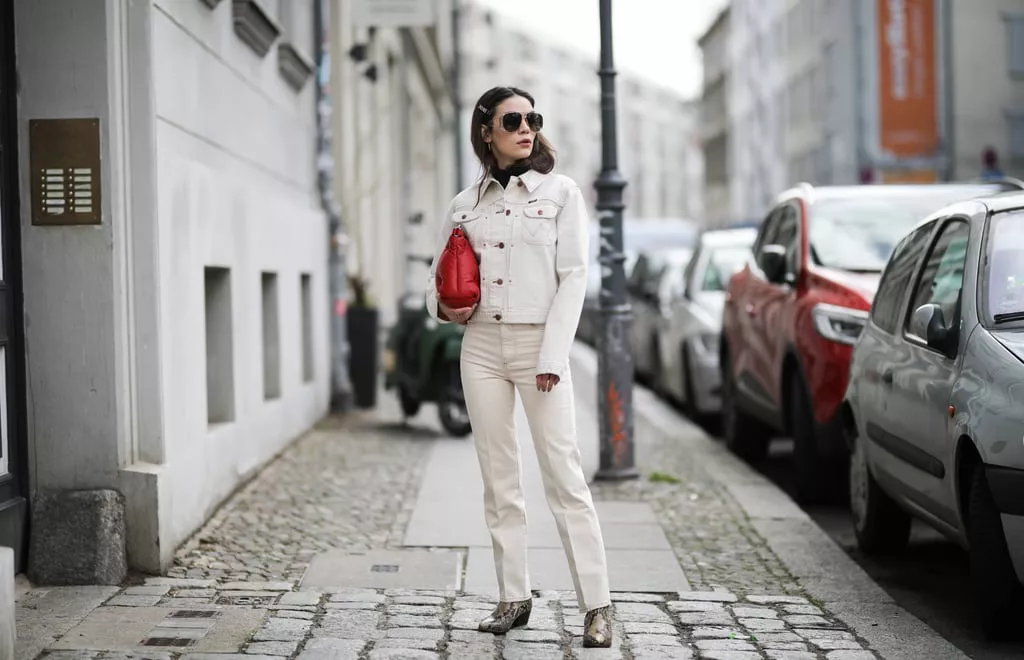 Девушка в белых прямых джинсах, куртка и красная сумка