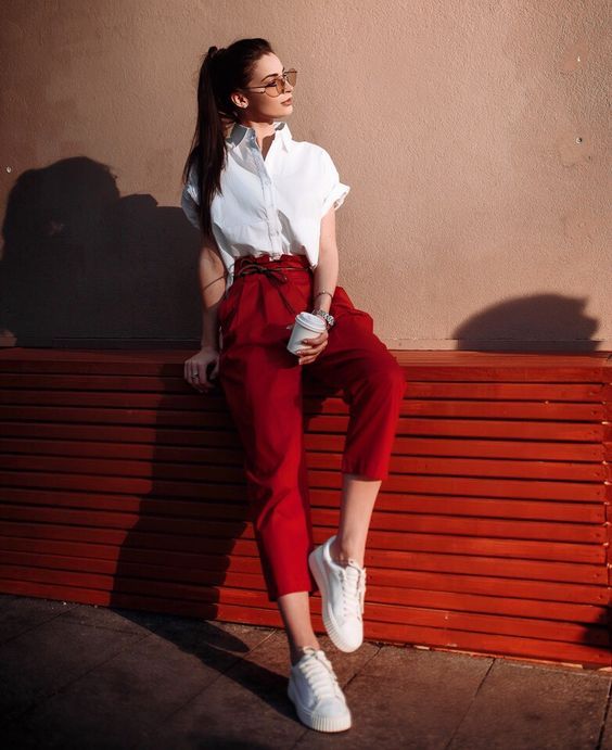 Девушка в красных брюках, белая рубашка и кеды