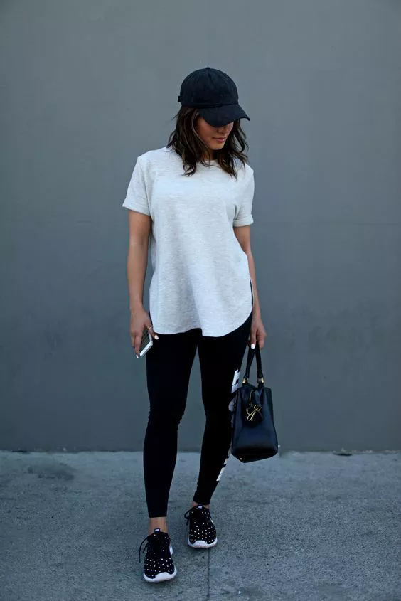 Девушка в спортивных лосинах, белая футболка и кепка