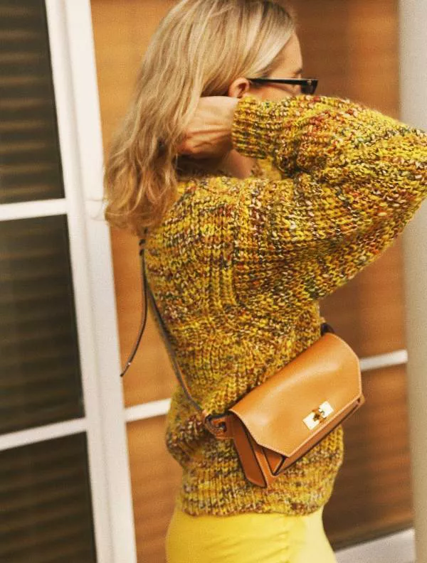 Девушка в желтых брюках, свитер и коричневая сумка