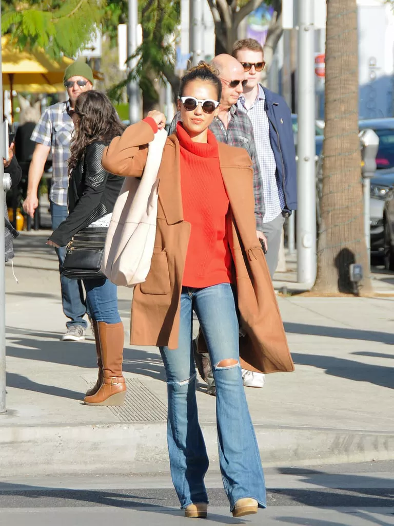 Джессика Альба в джинсах клеш, оранжевый свитер и коричневое пальто
