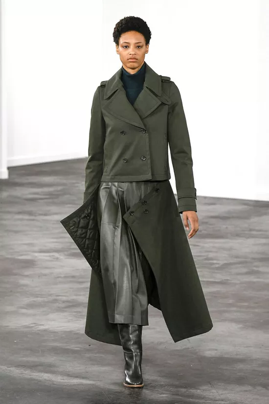 Модель в сером пальто, кожаная юбка миди и сапоги