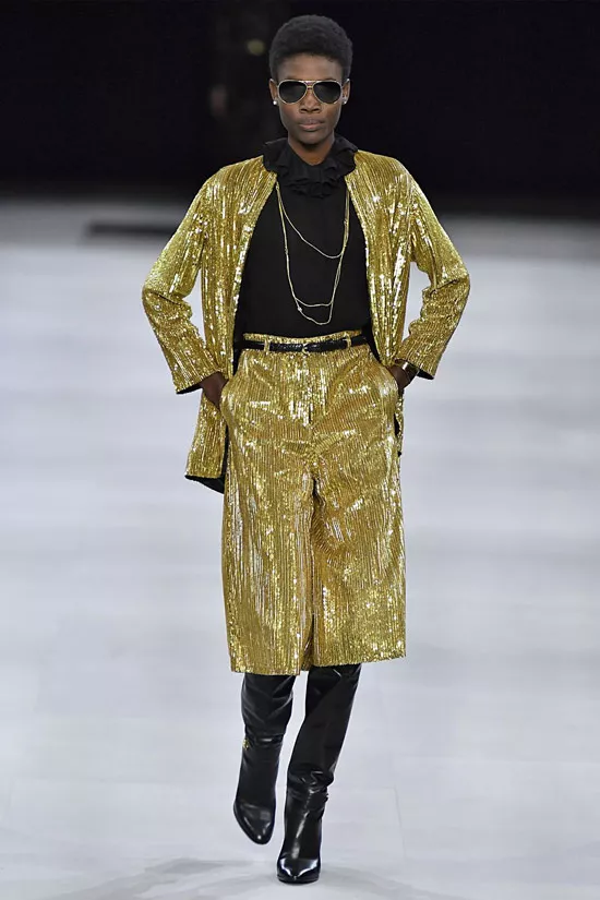 Модель в золотом костюме с бермудами, черная водолазка и сапоги