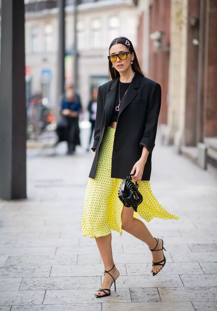 Девушка в черном блейзере, кроп топ и желтая юбка миди