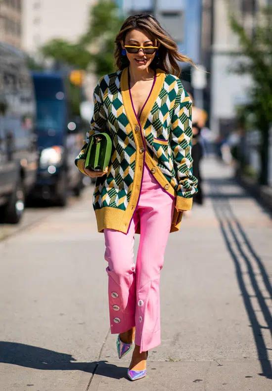 Девушка в розовых брюках, зеленый кардиган и металлические туфли