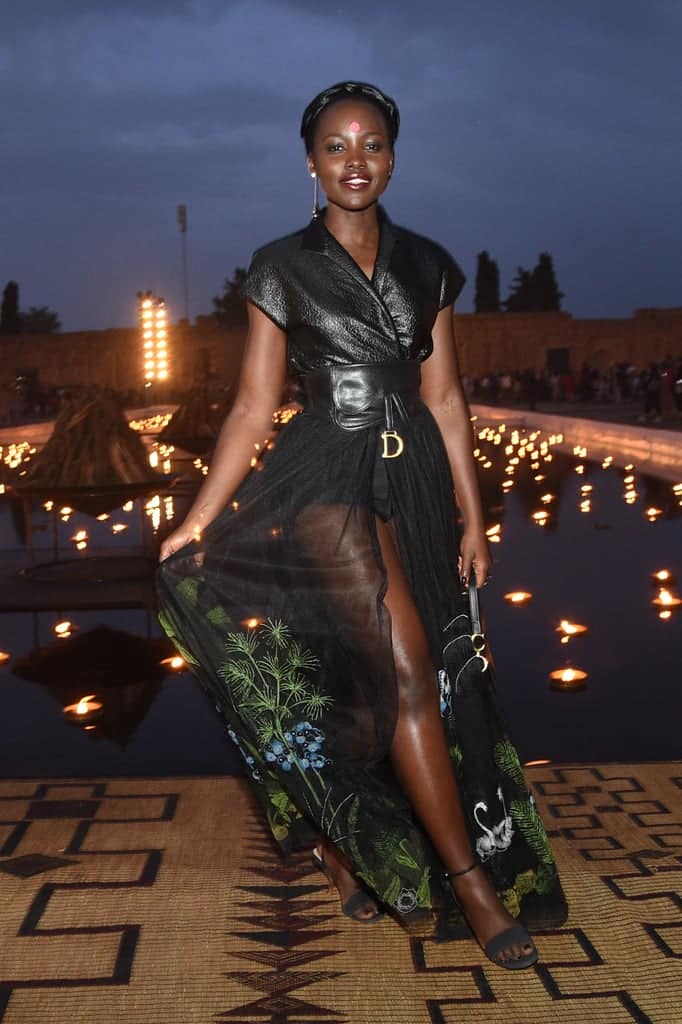 Lupita Nyongo в прозрачной черной юбке, кожаный топ и босоножки