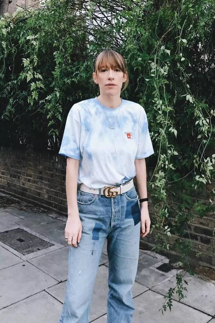Девушка в простой футболке, голубые джинсы и ремень