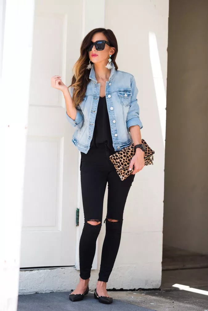 девушка в черных рванных джинсах, топ и джинсовая куртка