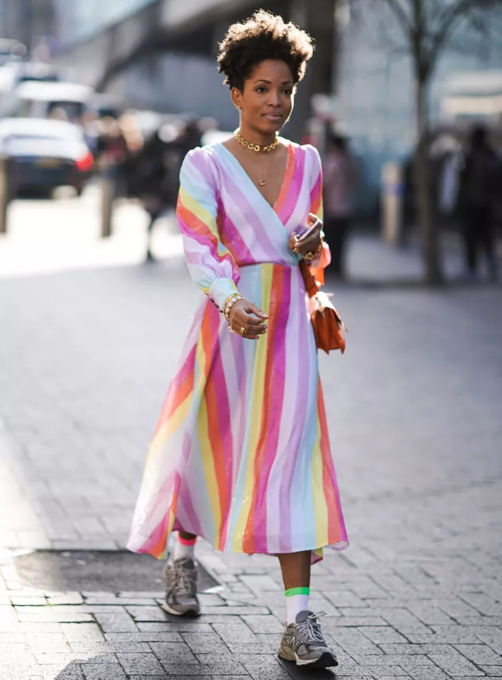 женщина в платье с принтом радуги и кроссовках