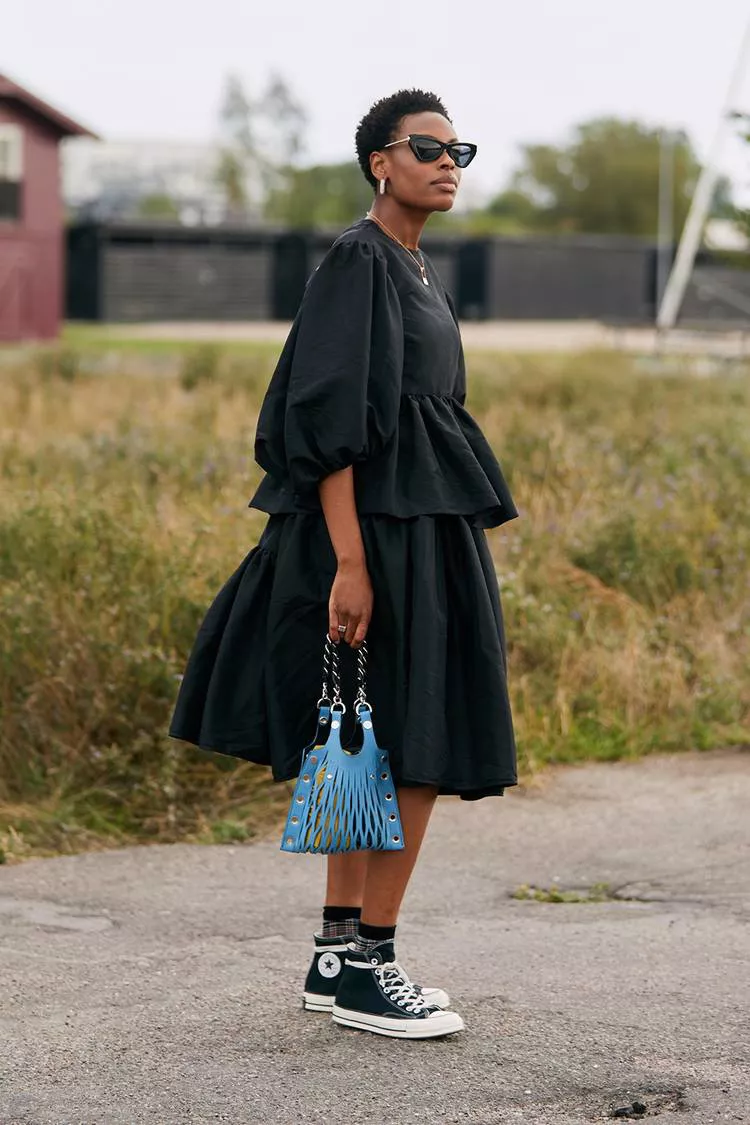 Девушка в черном платье миди, кеды и голубая сумочка