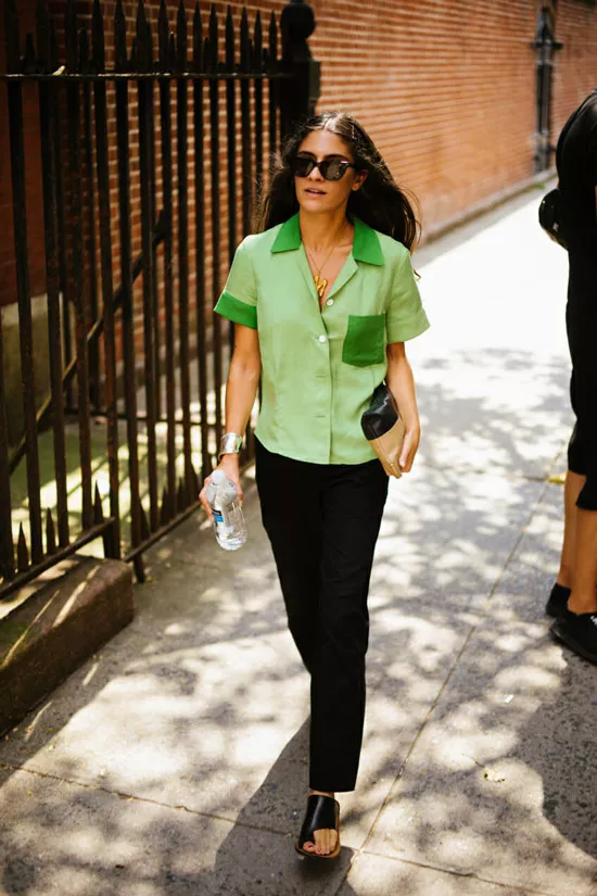 Девушка в черных брюках, зеленая рубашка и сандалии