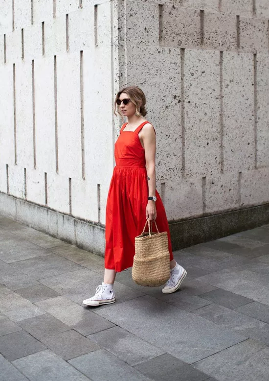Девушка в красном сарафане, белые кеды и соломенная сумка