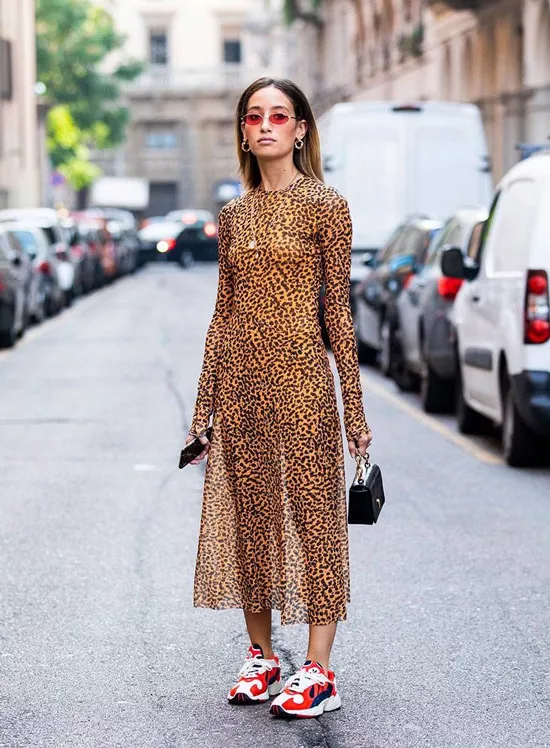 Девушка в леопардовом платье с длинными рукавами и кроссовках с яркими вставками