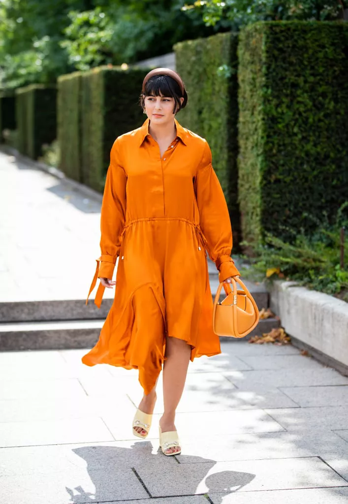 Девушка в оранжевом платье и светлые туфли