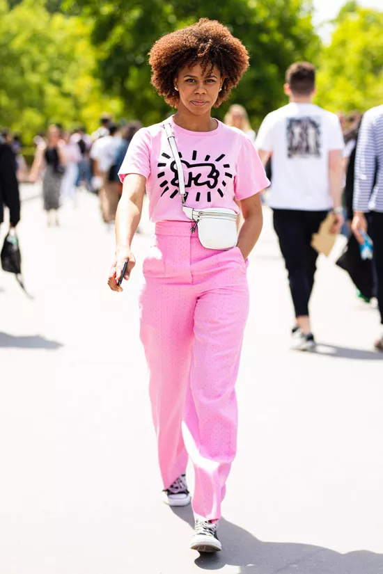 Девушка в розовых прямых брюках, футболка с принтом и кеды