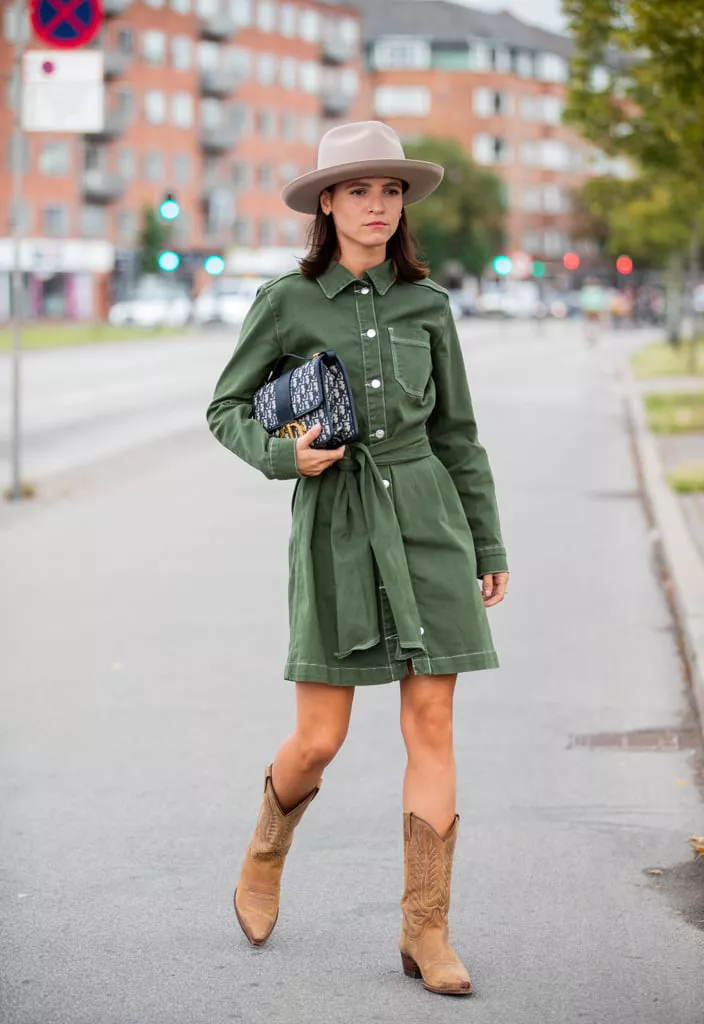 Девушка в зеленом коротком платье с поясом, ковбойсие сапоги и шляпа