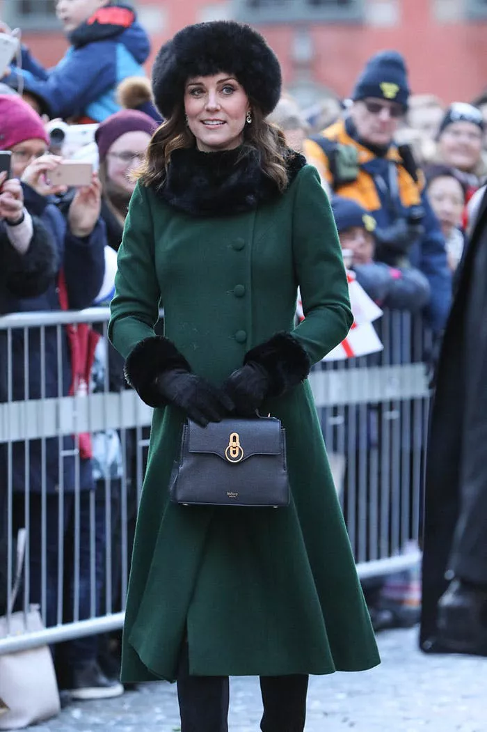 Кейт Миддлтон в зеленом приталенном пальто с меховой отделкой, меховая шапка и черная сумочка