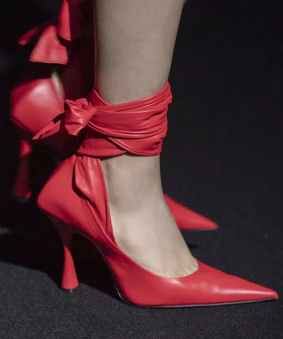 Модель в красных туфлях с острым носом и с завязками
