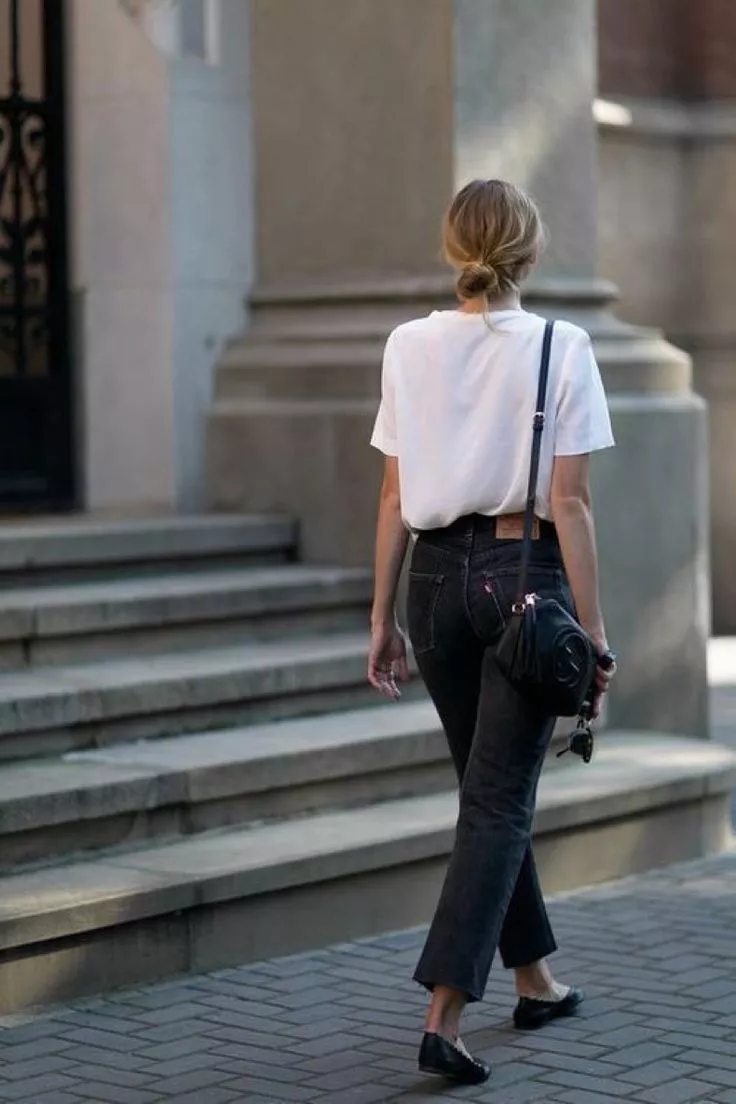 Девушка в простых серых джинсах и белая футболка