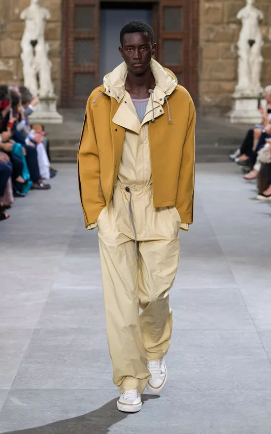 Модель в бежевом комбинезоне, желтая куртка и белые кеды