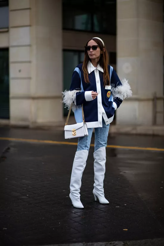 Девушка в голубых джинсах, высокие белые сапоги и джинсовая куртка