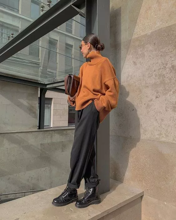 Девушка в серых просторных брюках, коричневый свитер оверсайз и ботинки